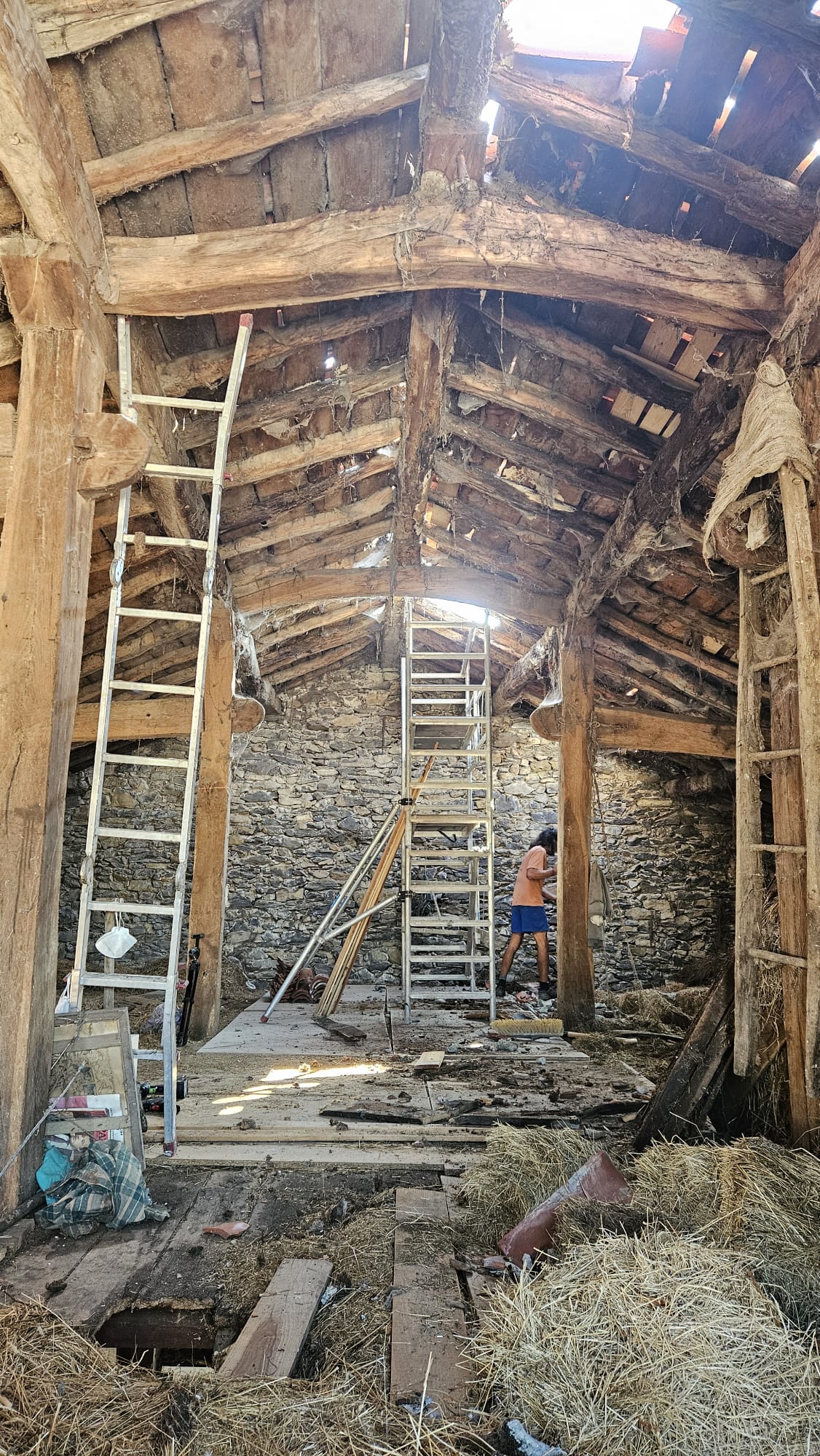Interior de la casa con la estructura original de madera y muros de piedra